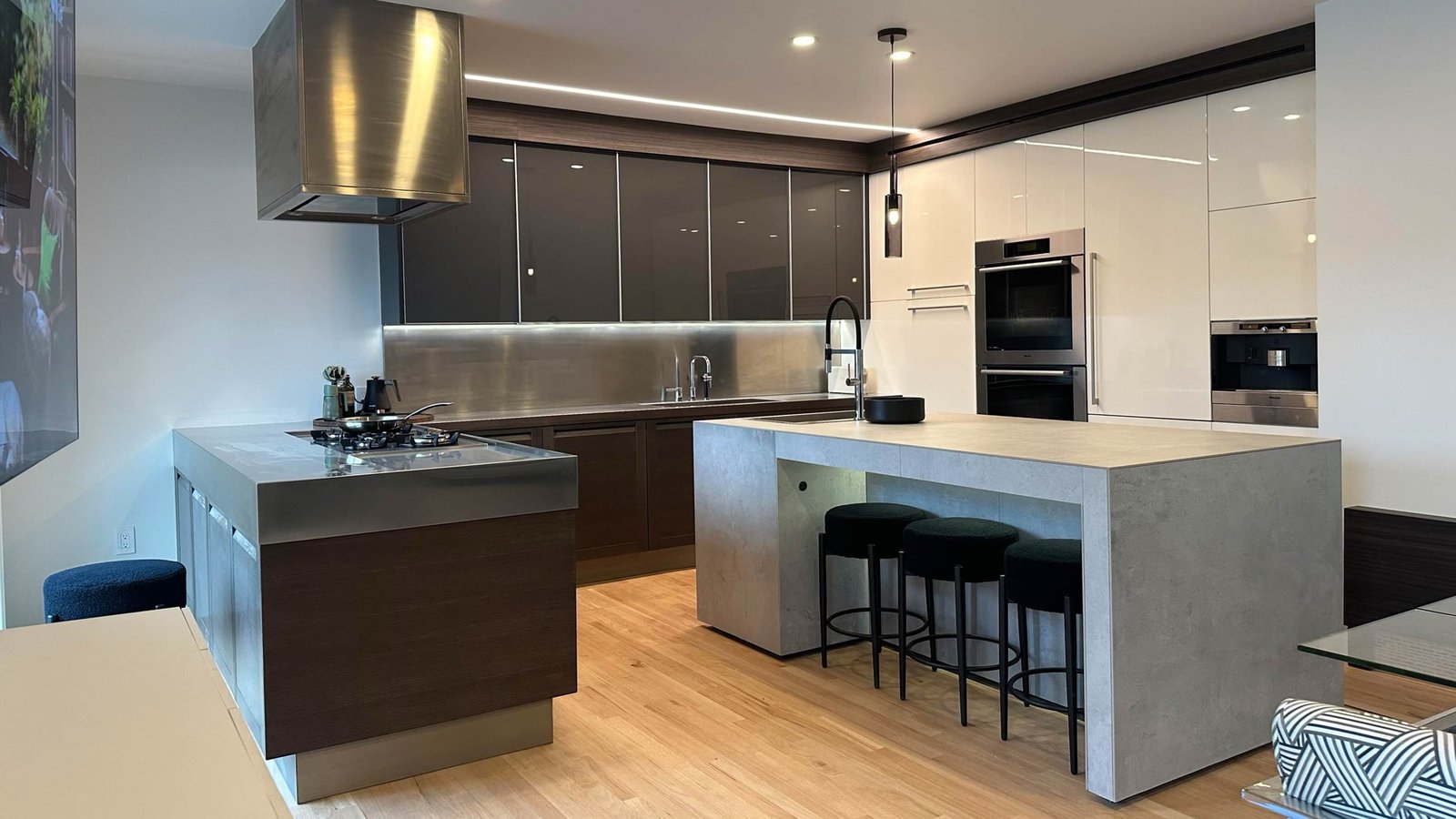 Contemporary kitchen with twin islands, stainless counters and wall ovens